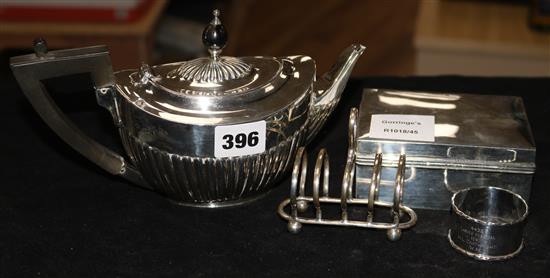 A silver teapot, a cigarette box, a toastrack and a napkin ring gross 22 oz.